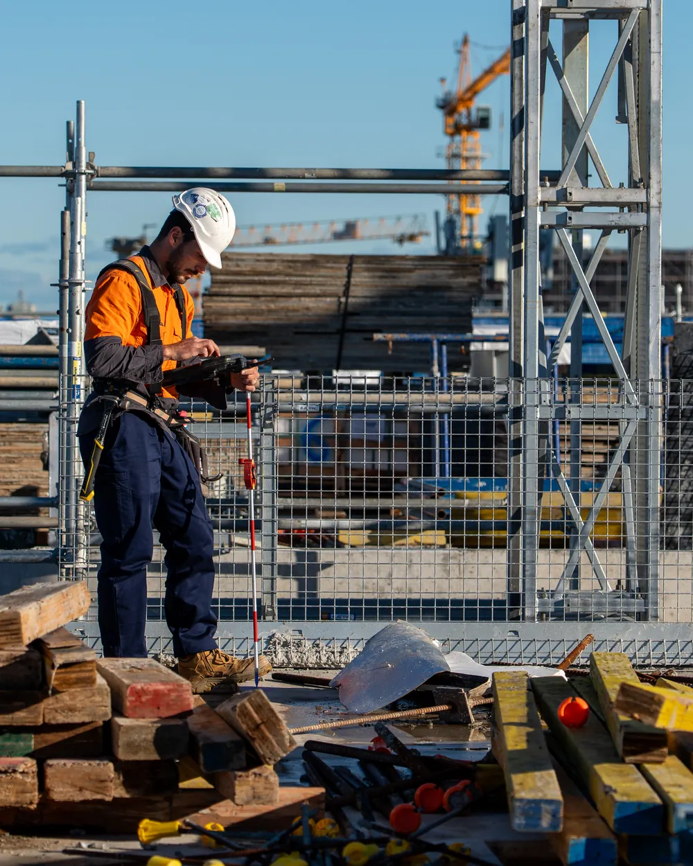 LCG surveyor recording data on a rooftop high-rise site with the Sydney skyline behind